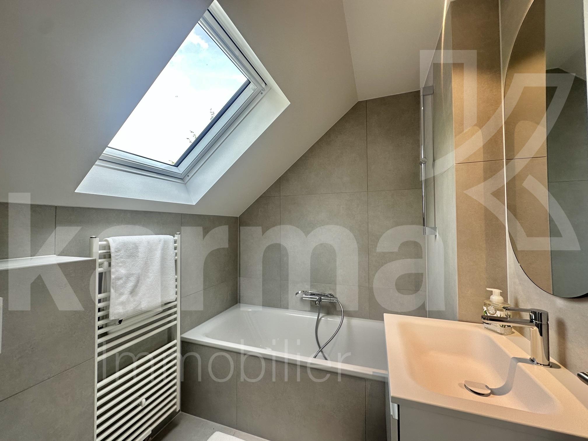 Modernes Dachbad mit Wanne und Dachfenster