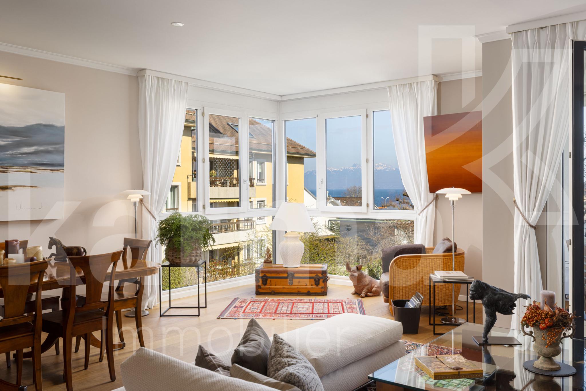 Helles Wohnzimmer mit Panoramafenstern und Seeblick
