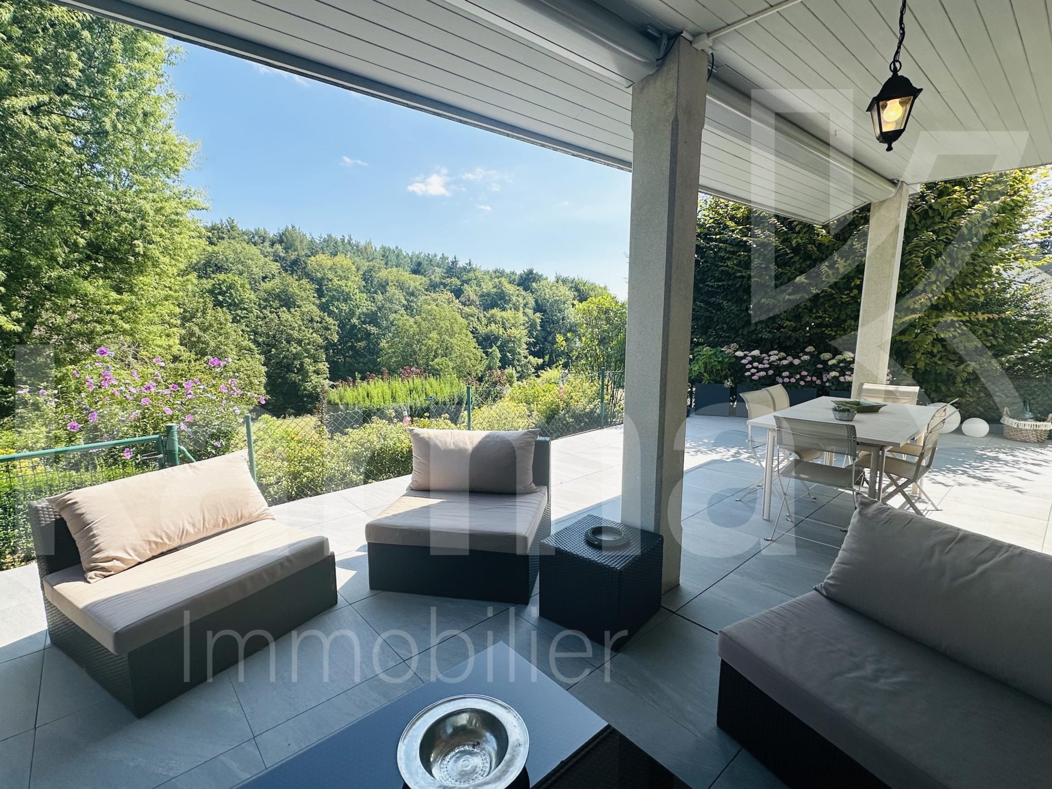 Überdachte Terrasse mit Gartenblick