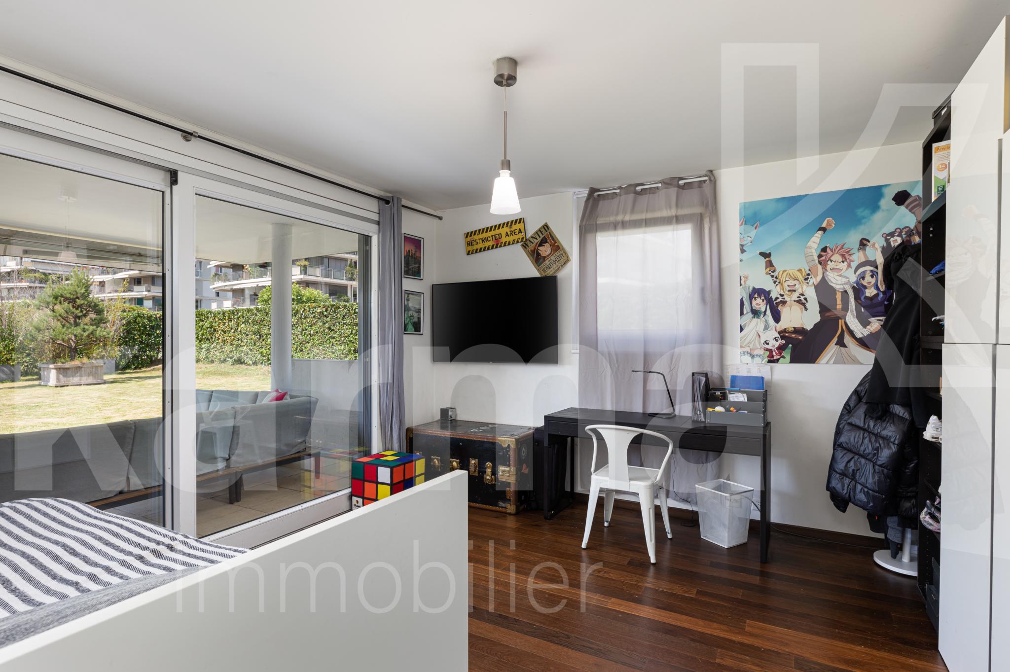 Helles Schlafzimmer mit Arbeitsbereich und Balkonzugang