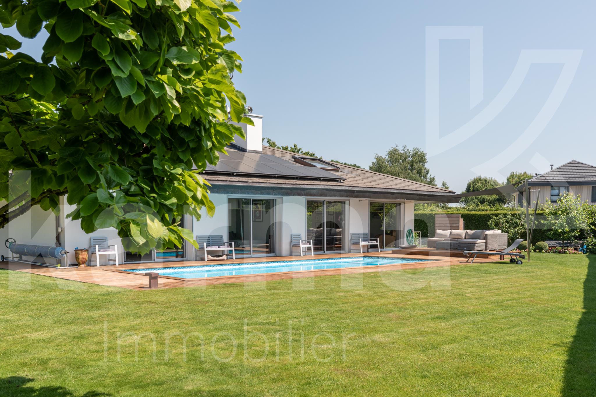 Außenansicht eines modernen Hauses mit Pool und großem Garten