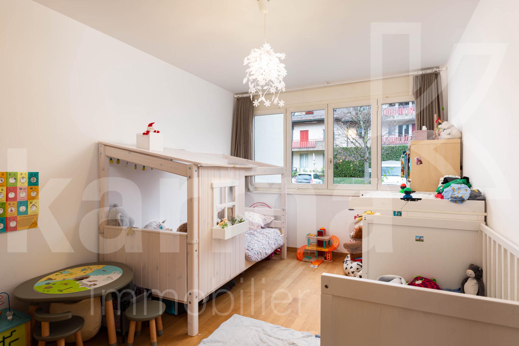Kinderzimmer mit großem Fenster und hellem Holzboden