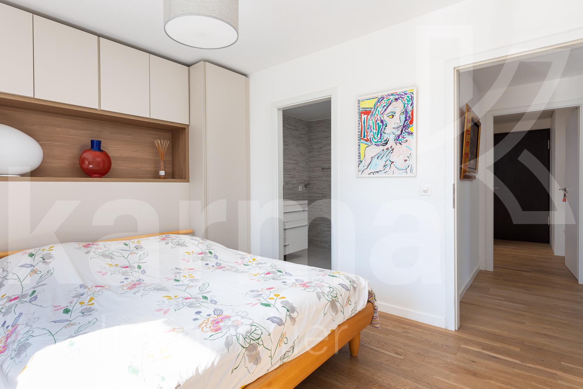 Helles Schlafzimmer mit Einbauschrank und Blick ins Bad