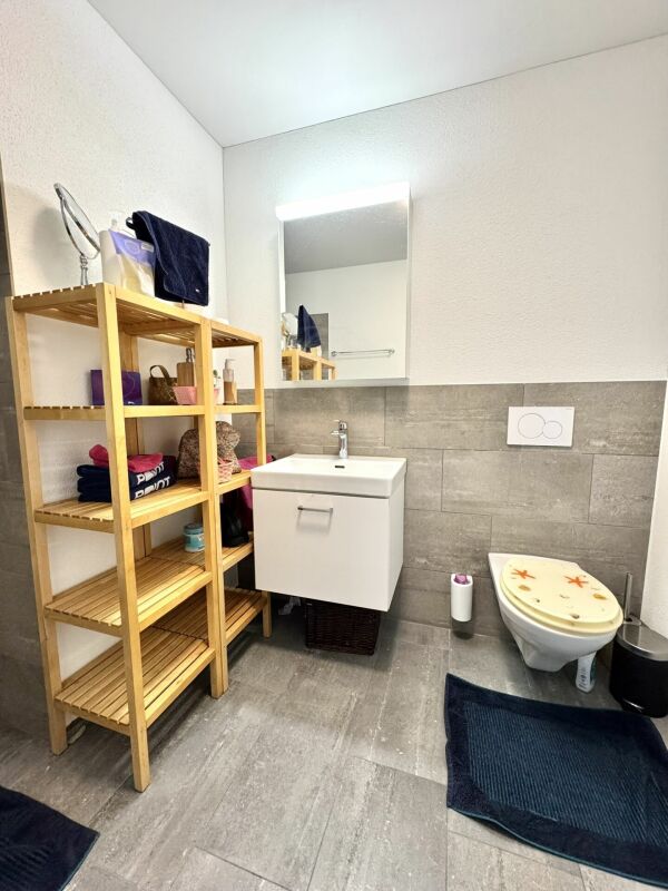Modernes Gäste-WC mit Holzregal und wandhängendem Waschtisch
