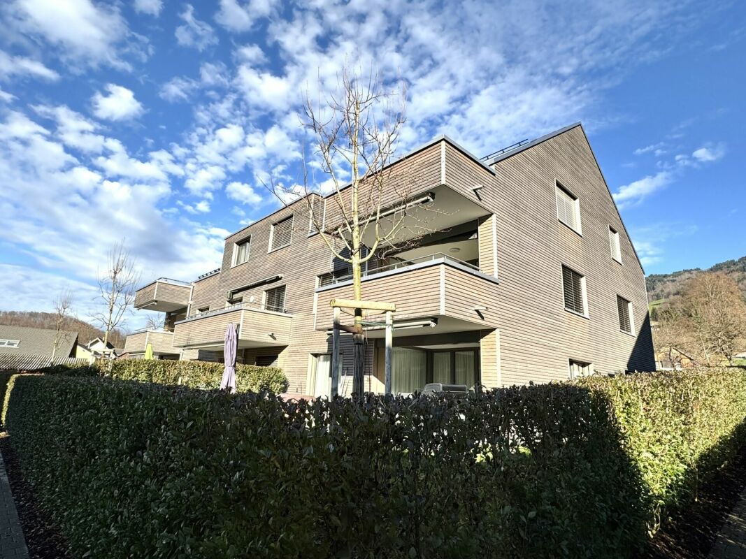 Mehrfamilienhaus mit Holzfassade und Balkonen