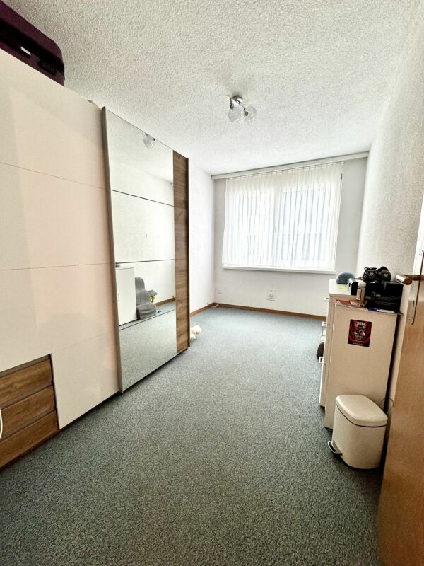 Schlafzimmer mit Einbauschrank und großem Fenster