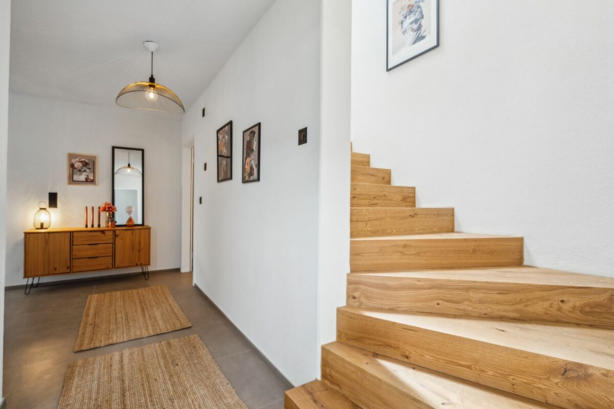 Moderner Flur mit Holztreppe