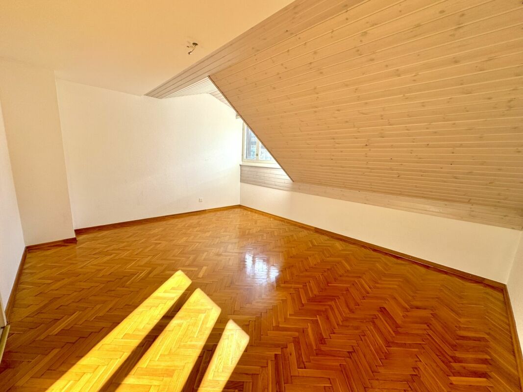 Leerer Dachraum mit Holzdecke und Parkettboden