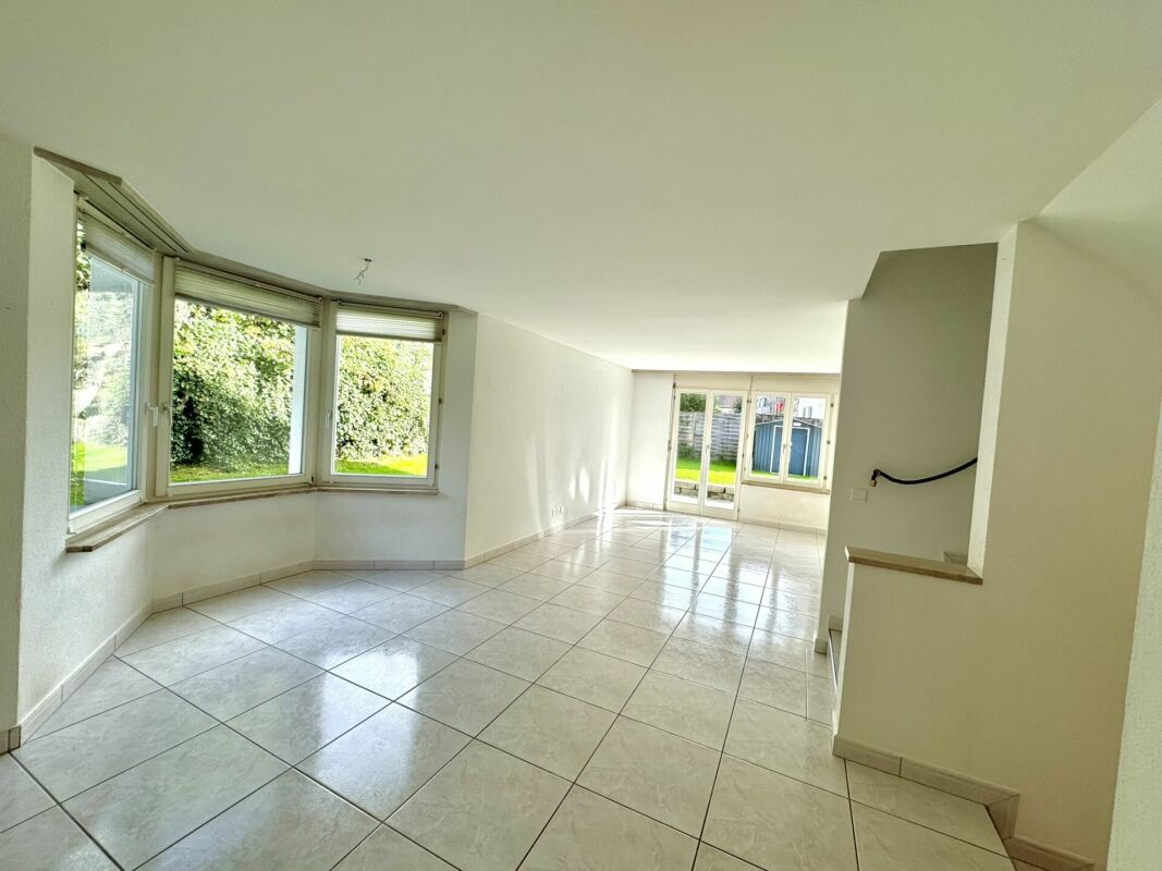 Helles, leeres Wohn-/Esszimmer mit Fliesenboden