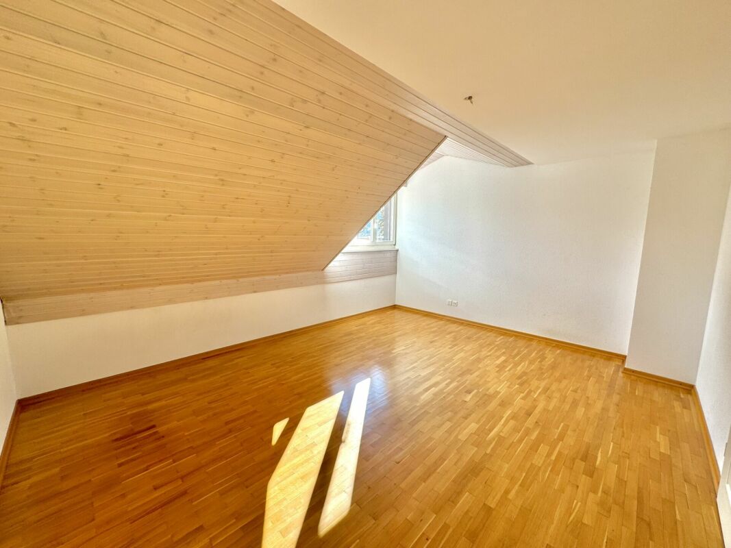Dachgeschosszimmer mit Holzdecke und Parkett