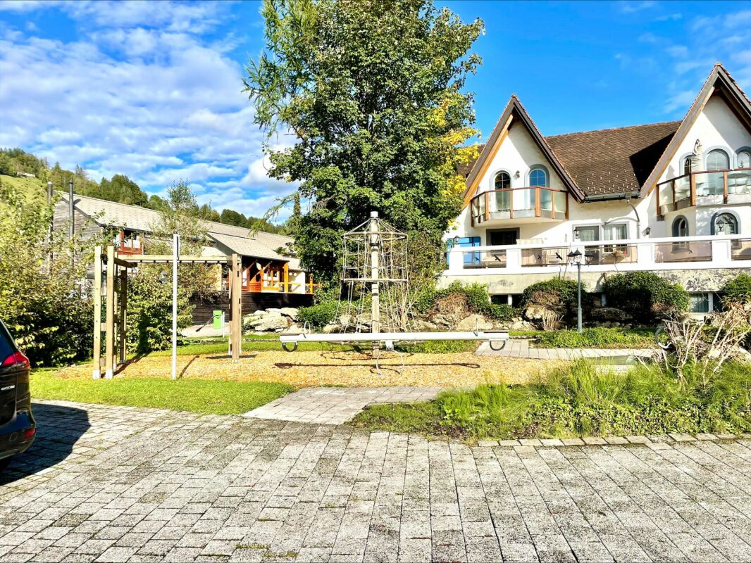 Außenansicht eines Wohngebäudes mit Garten und Spielbereich