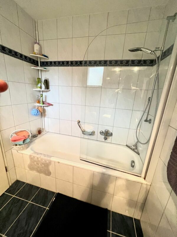 Badezimmer mit Badewanne und Duschabtrennung