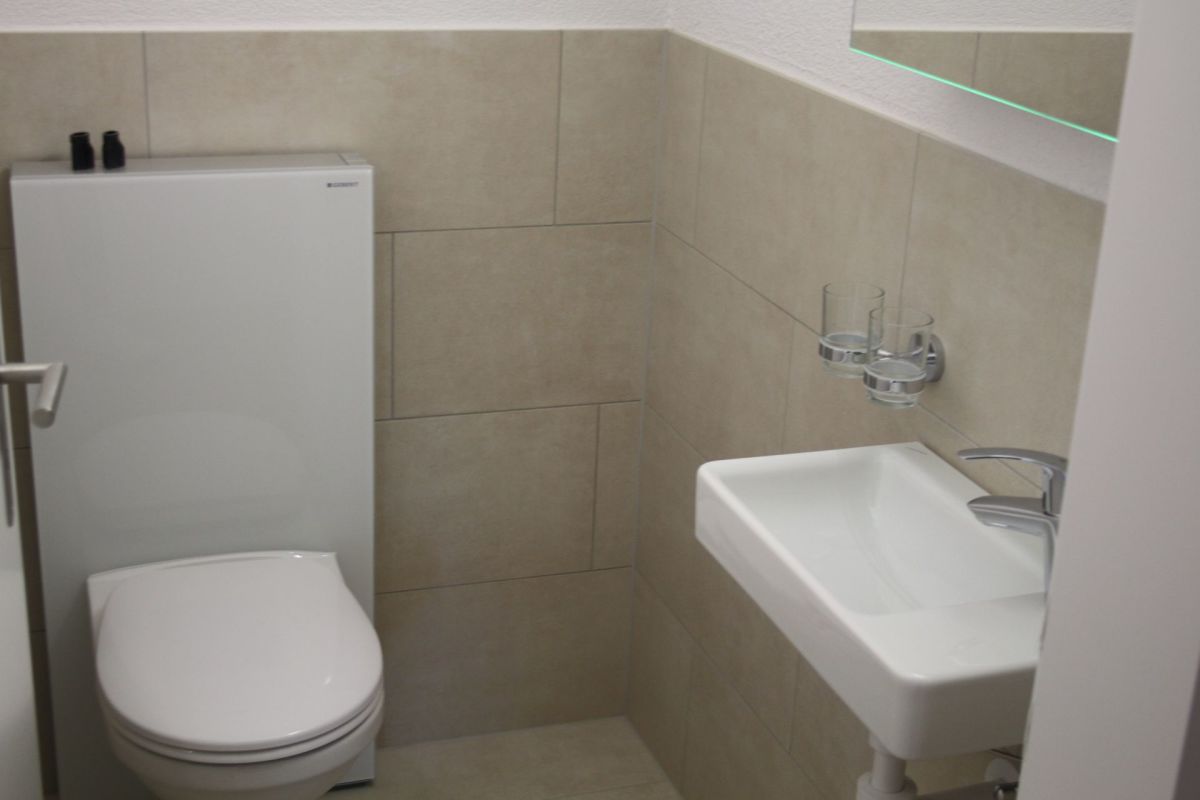 Gäste-WC mit wandhängendem WC und kleinem Handwaschbecken