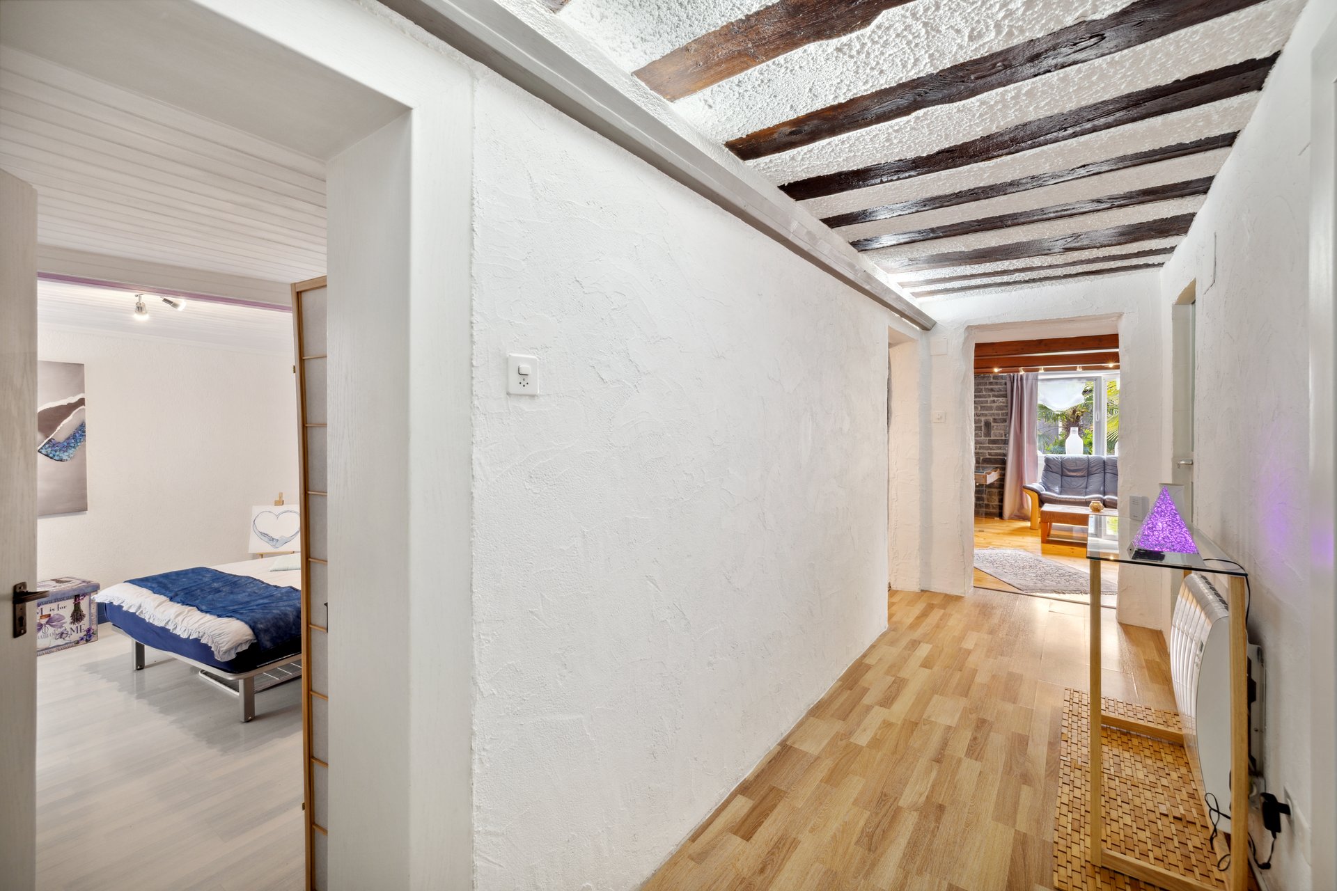 Flur mit sichtbaren Holzbalken und angrenzendem Zimmer