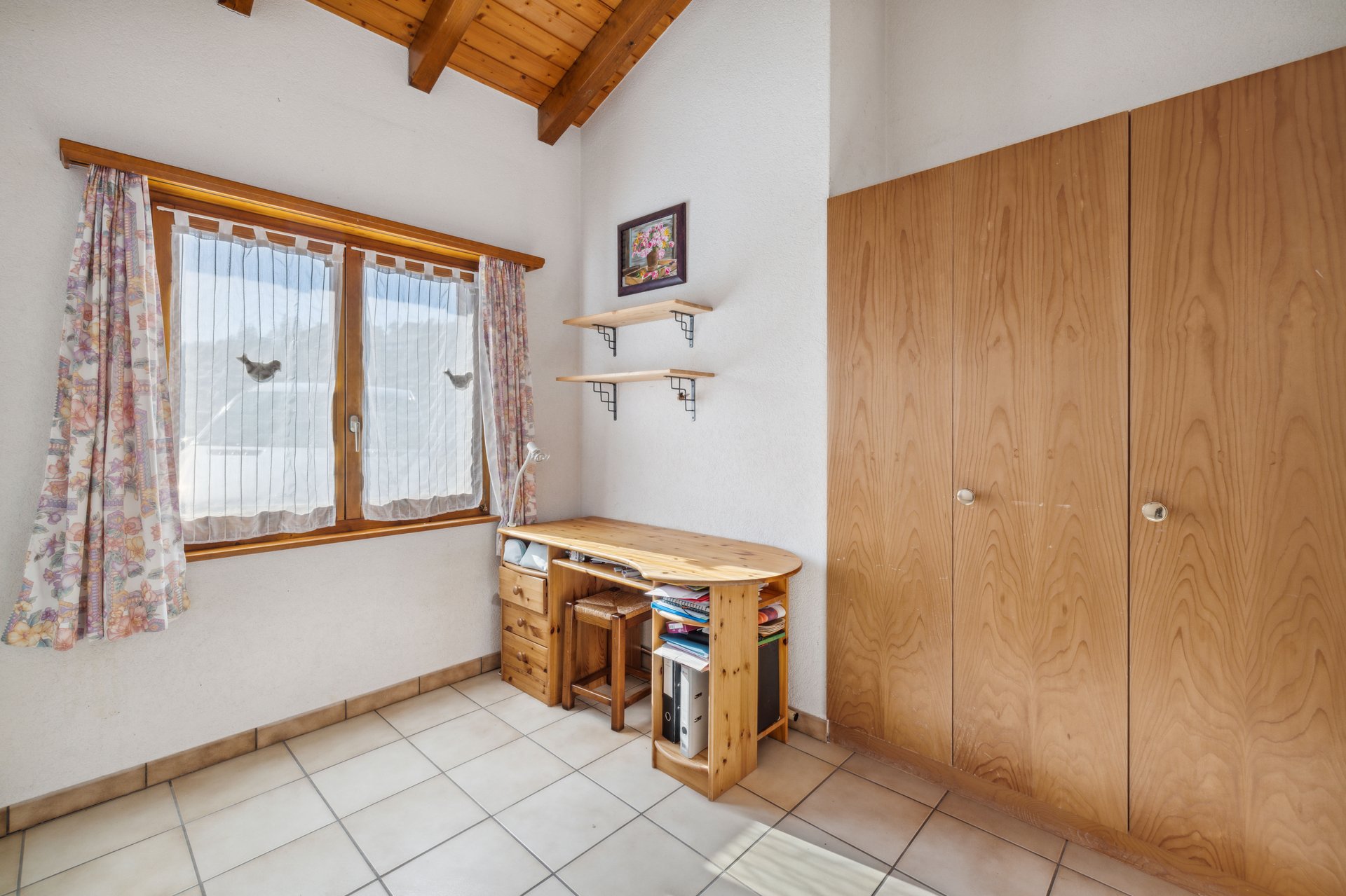 Helles Zimmer mit Dachbalken und Holzschrank
