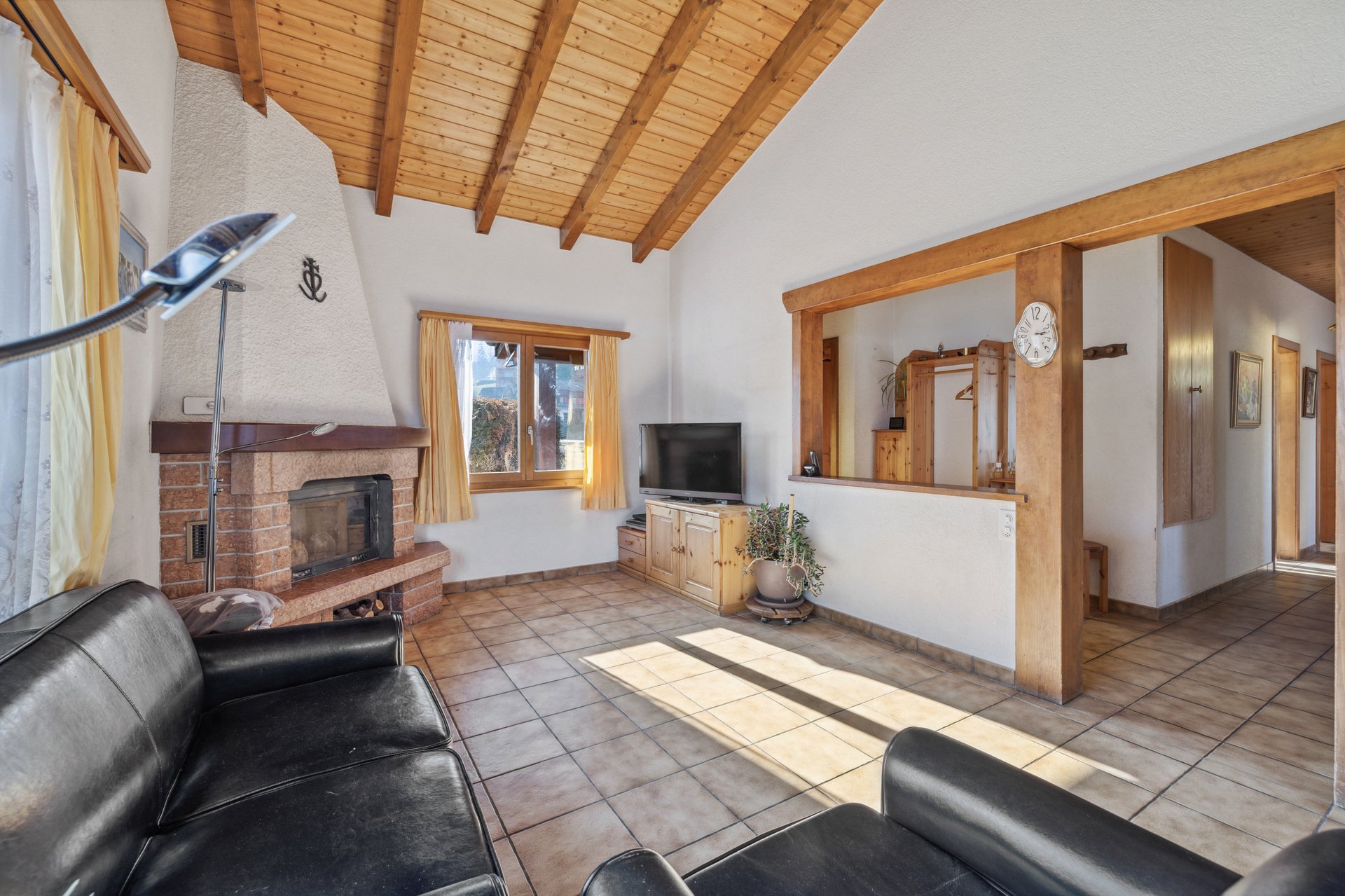Wohnzimmer mit Kamin und sichtbarer Holzdecke