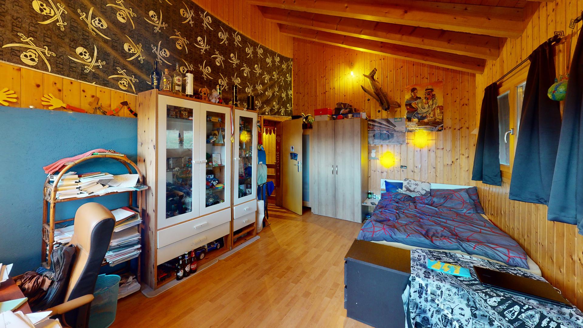 Rustikal eingerichtetes Schlafzimmer mit Holzverkleidung