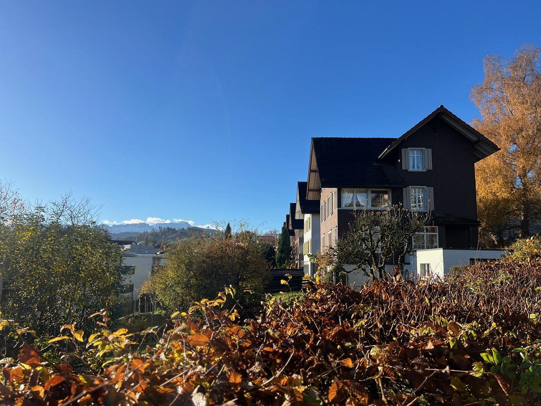 Außenansicht eines Wohngebäudes mit Garten und Bergblick
