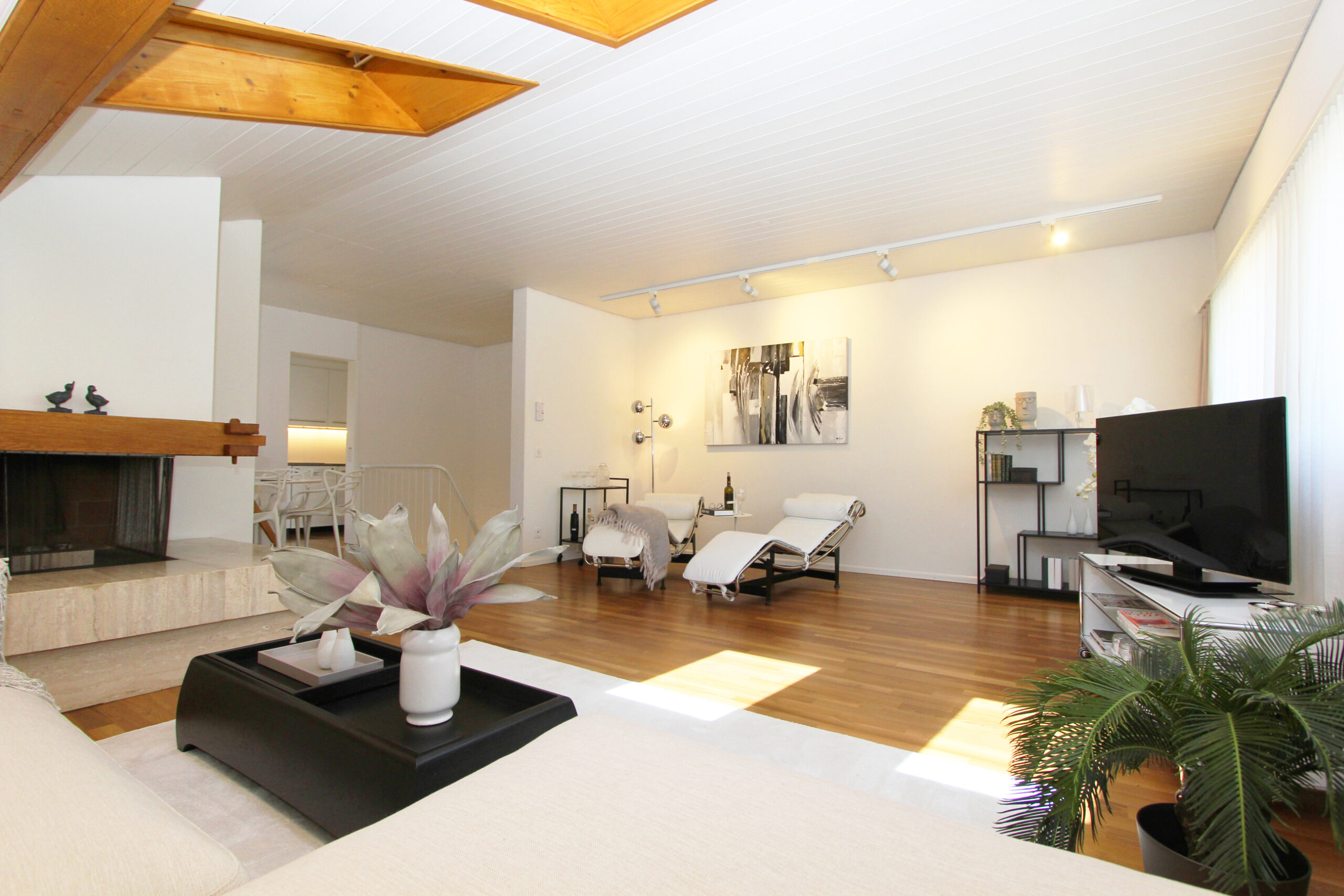 Helles Wohnzimmer mit Kamin und Lounge-Bereich