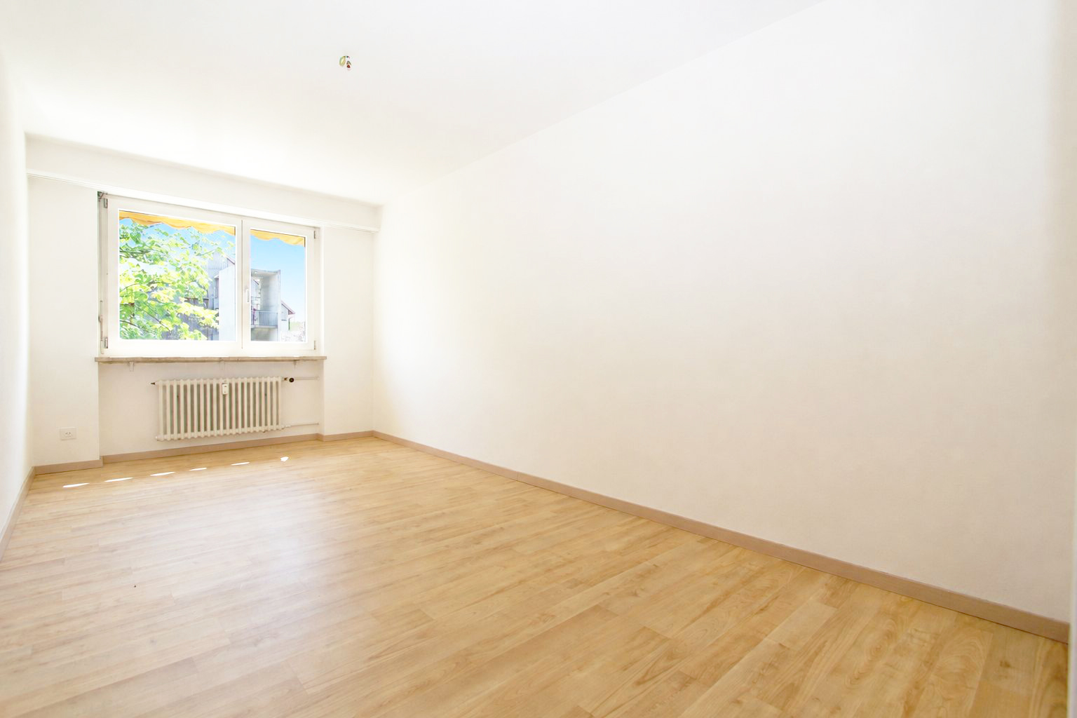 Heller, leerer Wohnraum mit Fenster