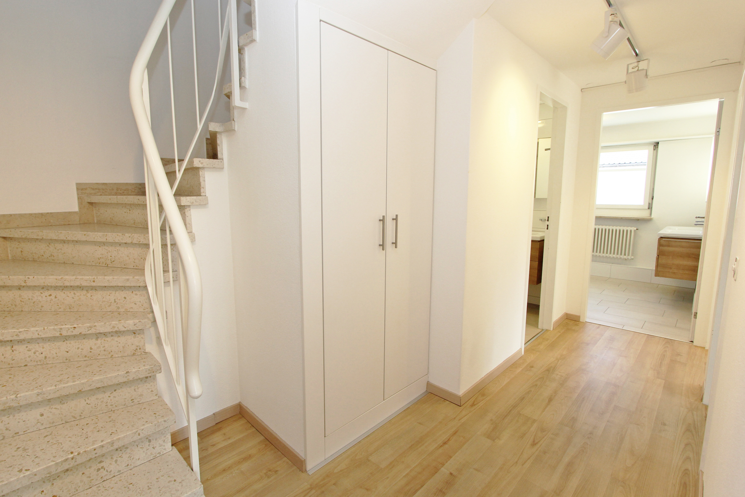Heller Flur mit Treppe und Einbauschrank
