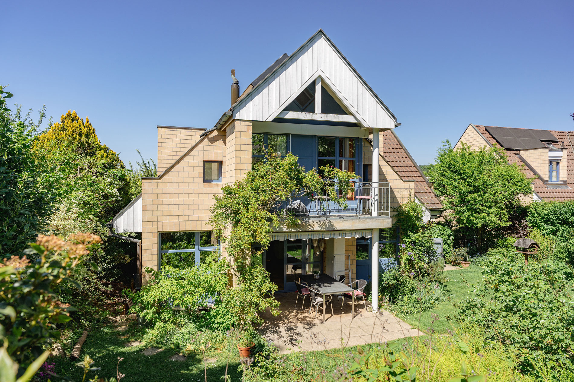 Gartenansicht eines Hauses mit Balkon und Terrasse