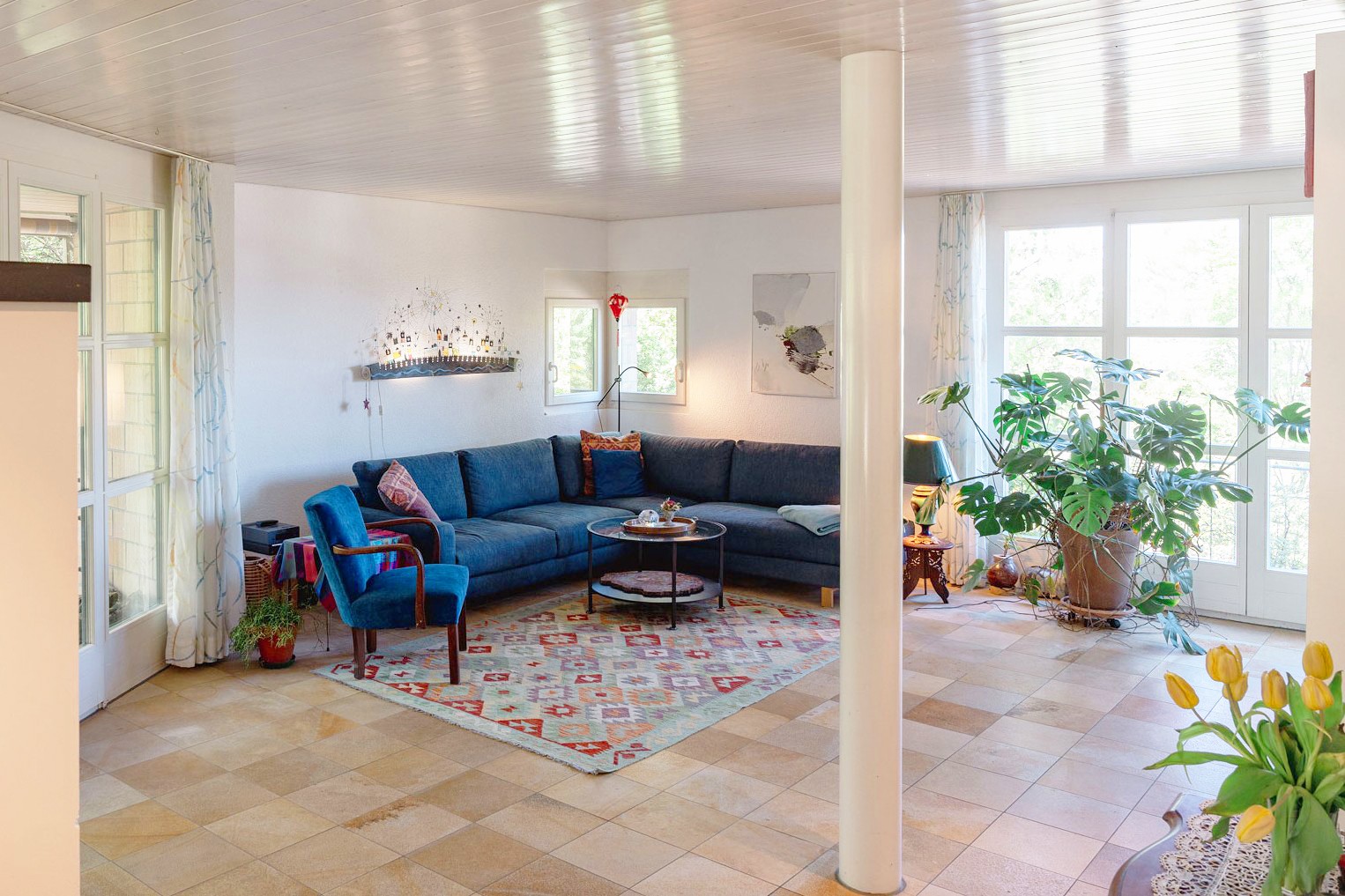 Heller Wohnbereich mit großer Fensterfront und Sofa-Ecke