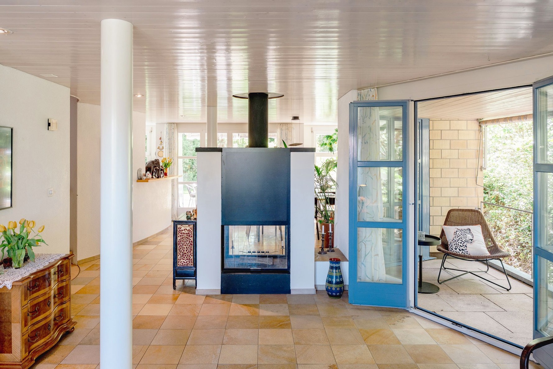 Offener Wohnbereich mit Kamin und Balkonzugang