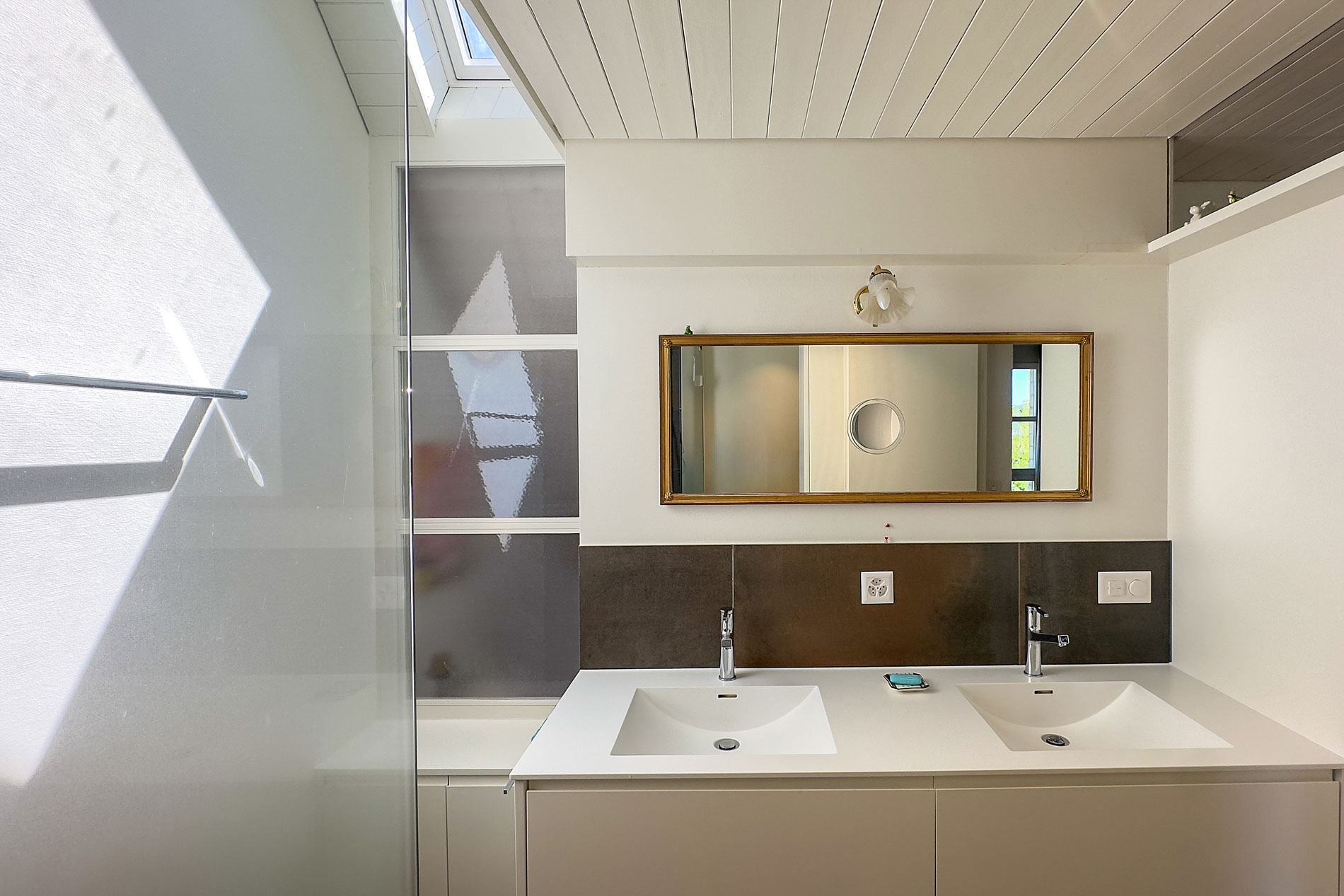 Modernes Badezimmer mit Doppelwaschtisch und Dachfenster