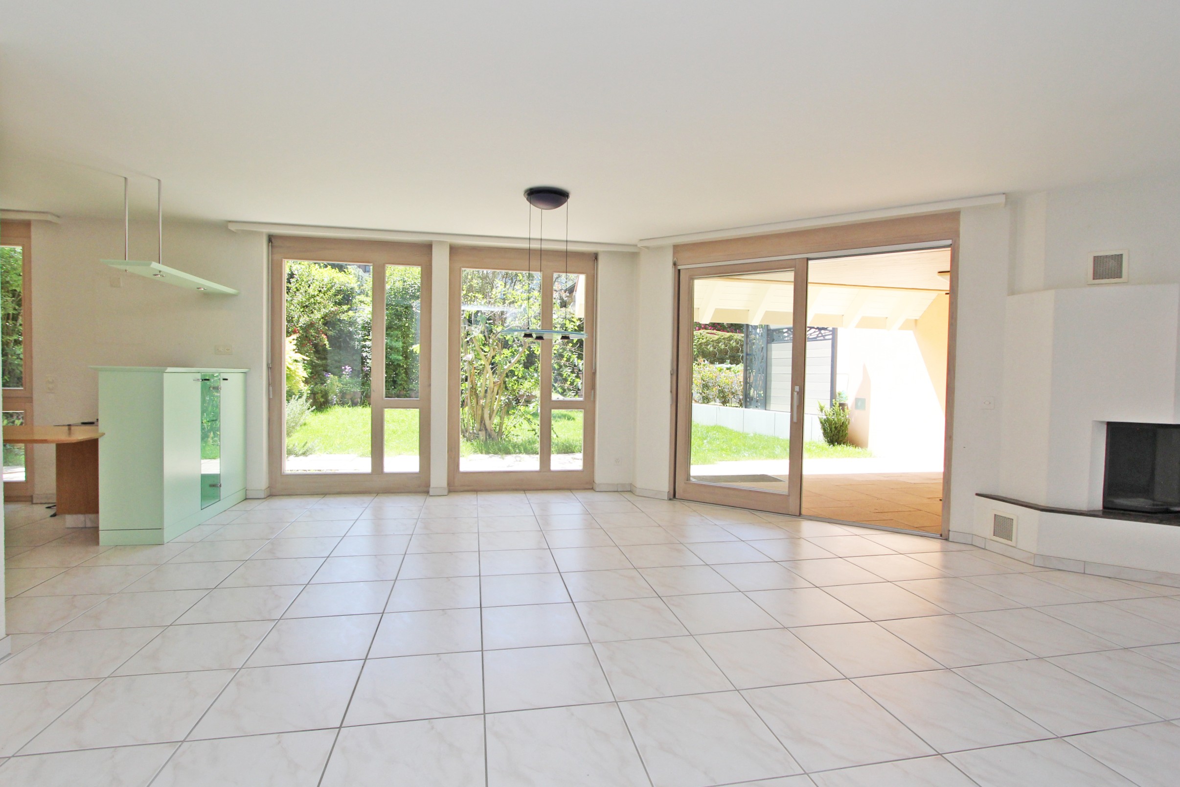 Heller Wohnraum mit bodentiefen Fenstern und Zugang zur Terrasse