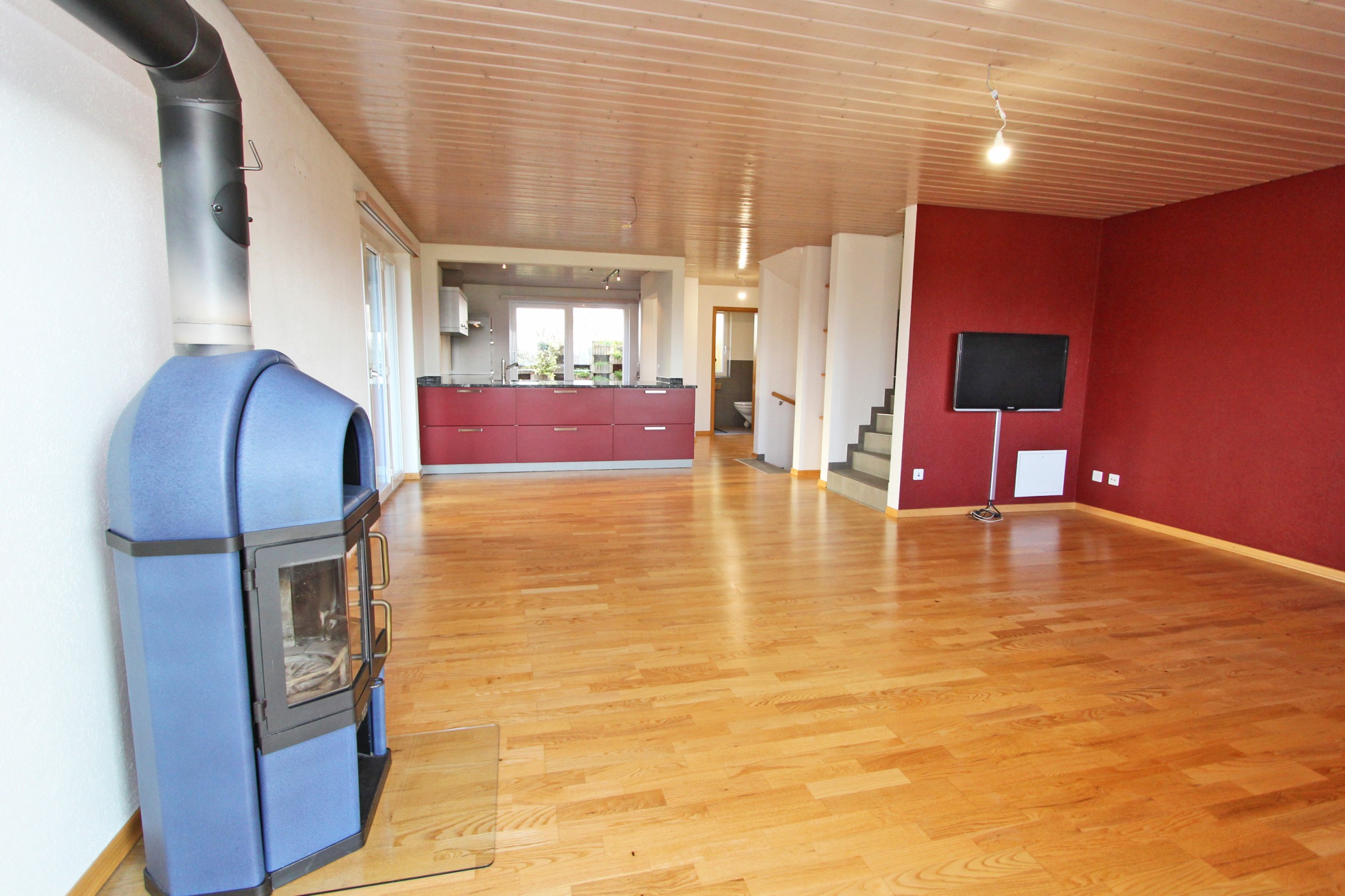 Offener Wohnraum mit Kamin und Küche