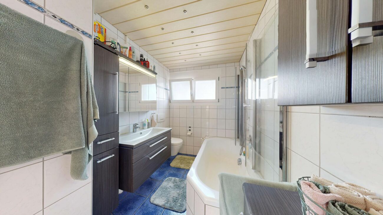 Badezimmer mit Badewanne und Doppelwaschtisch