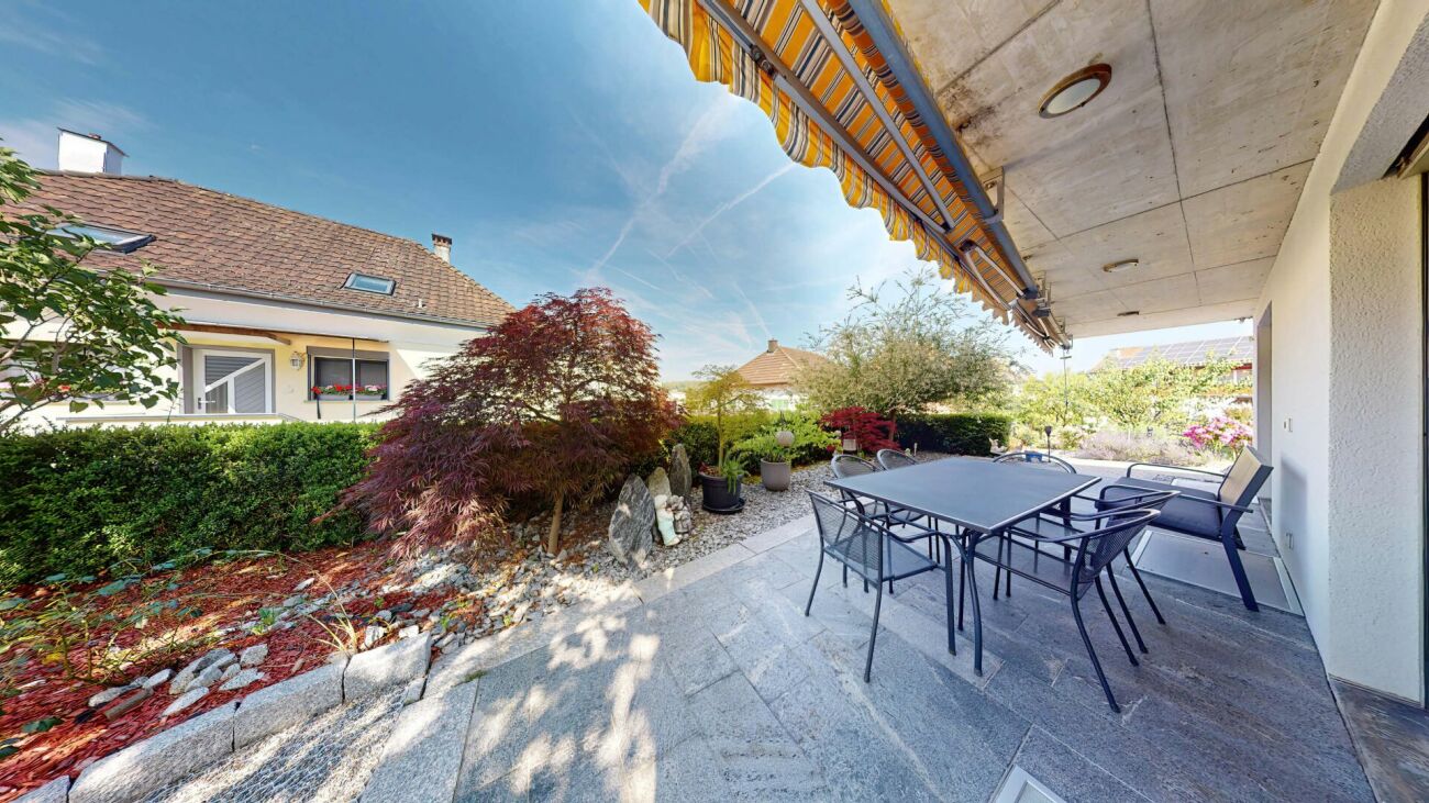 Überdachte Terrasse mit Gartenblick