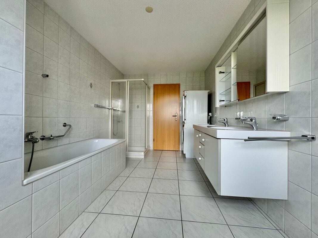 Badezimmer mit Wanne und Waschplatz