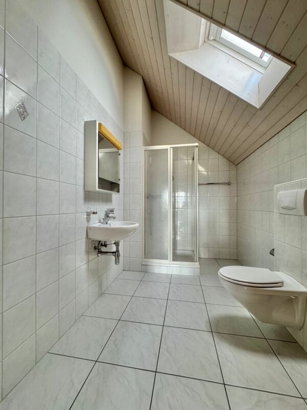 Dachgeschoss-Badezimmer mit Dusche und WC