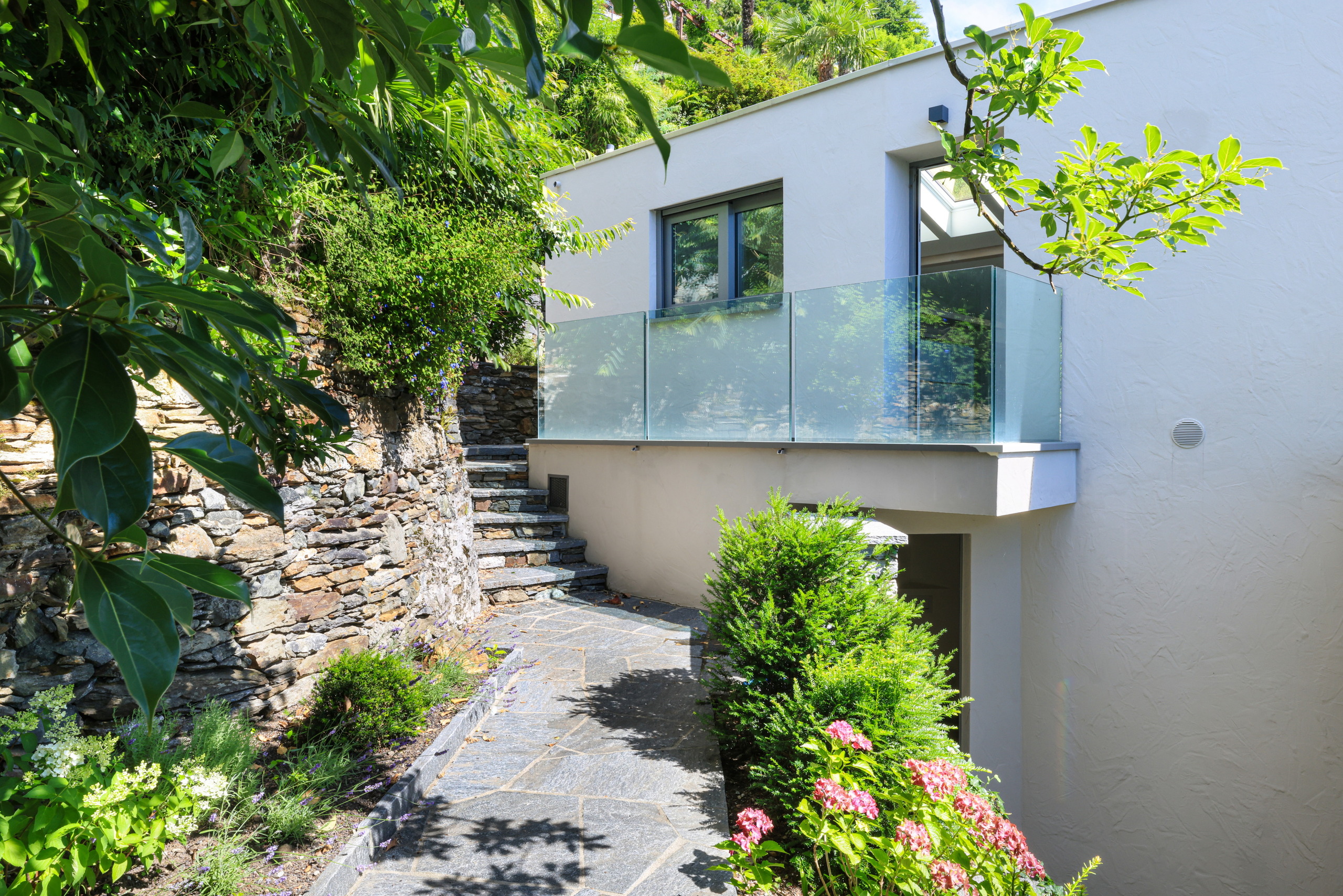 Mediterraner Außenbereich mit Terrasse und Glasgeländer