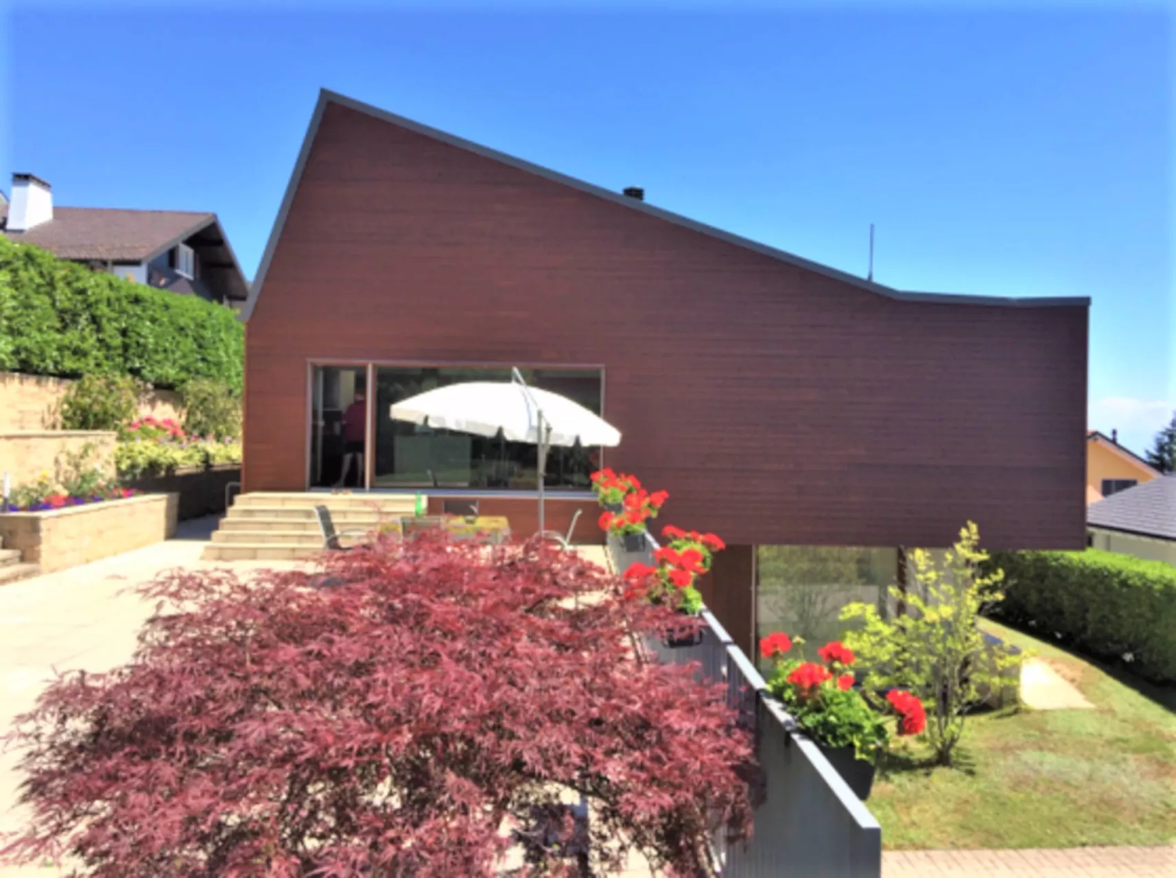 Modernes Haus mit geneigtem Dach und Garten