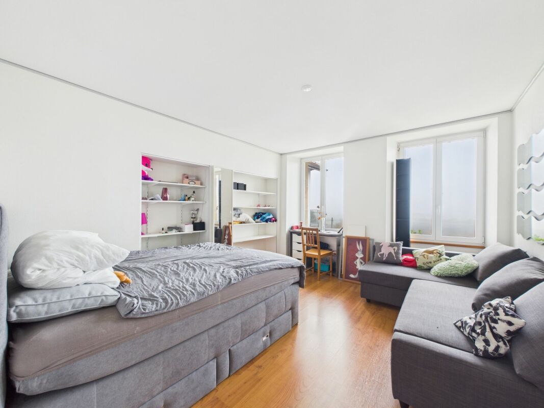Helles Schlafzimmer mit Wohnbereich und Schreibtisch