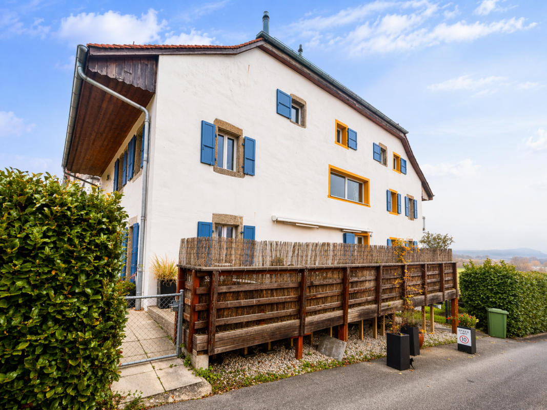 Landhaus mit Holzterrasse und blauen Fensterläden