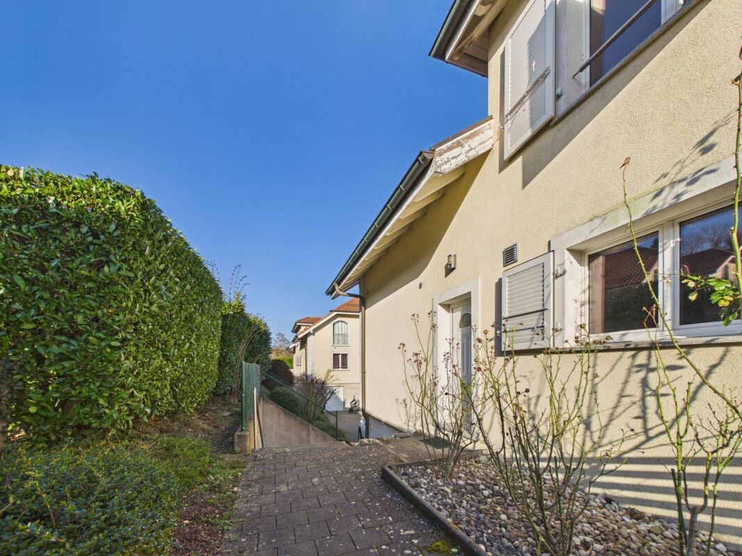 Außenansicht eines Wohnhauses mit seitlichem Weg