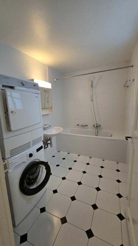 Badezimmer mit Waschmaschine und Wanne