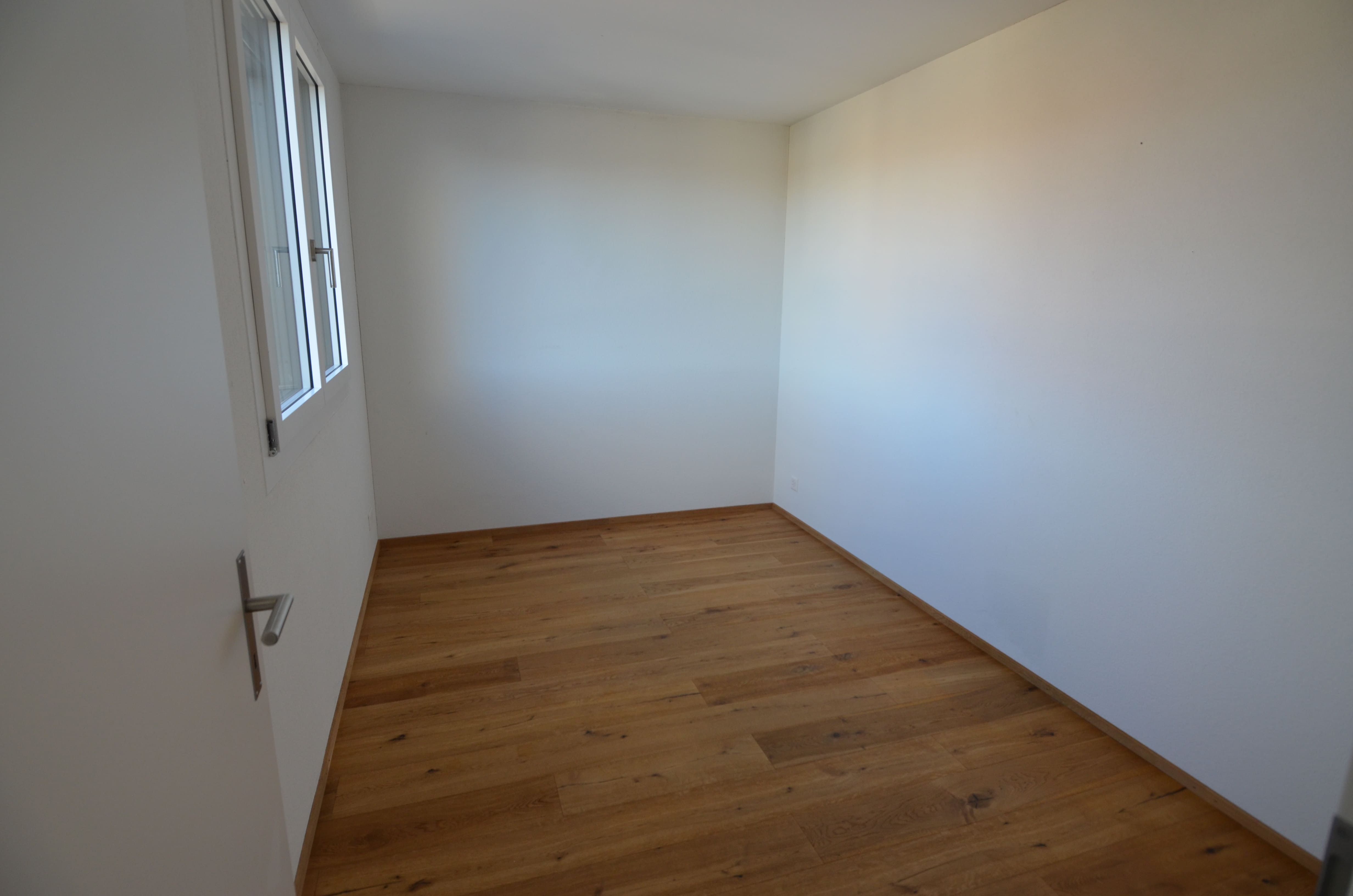 Leerer Raum mit Holzparkett und Fenster