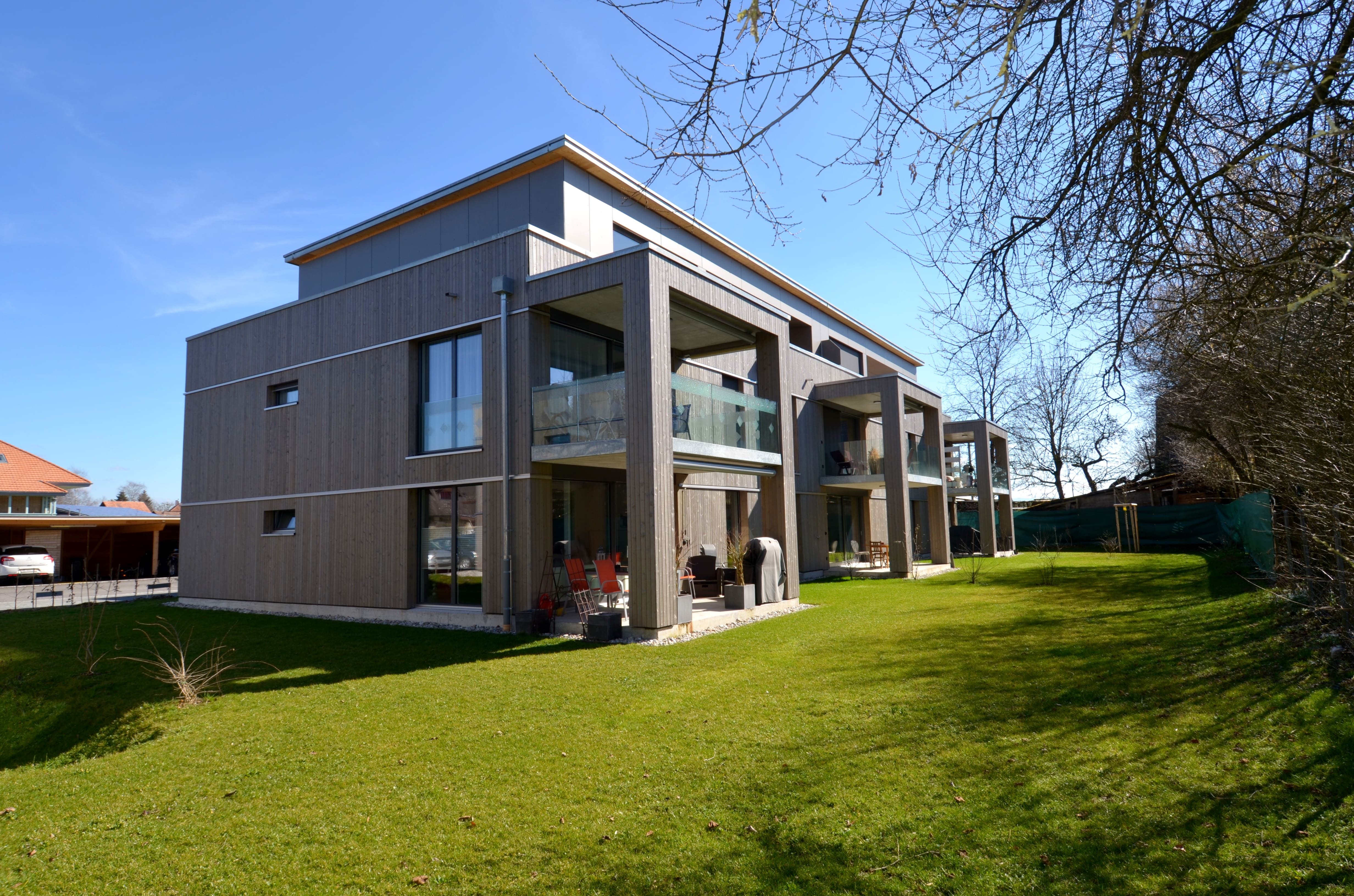 Modernes Mehrfamilienhaus mit Holzfassade und Balkonen
