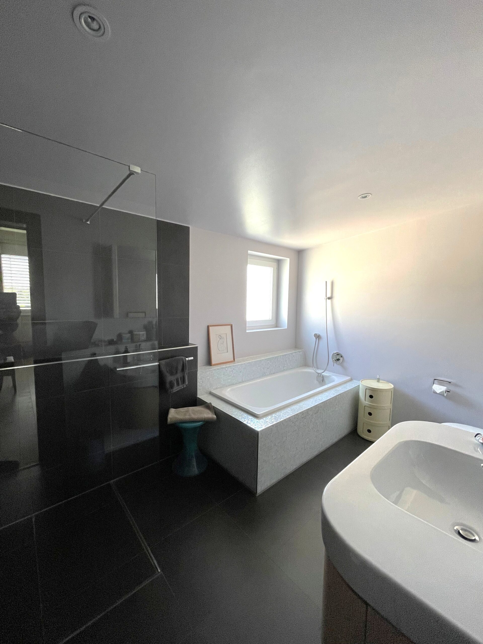 Modernes Badezimmer mit Badewanne und dunkler Akzentwand