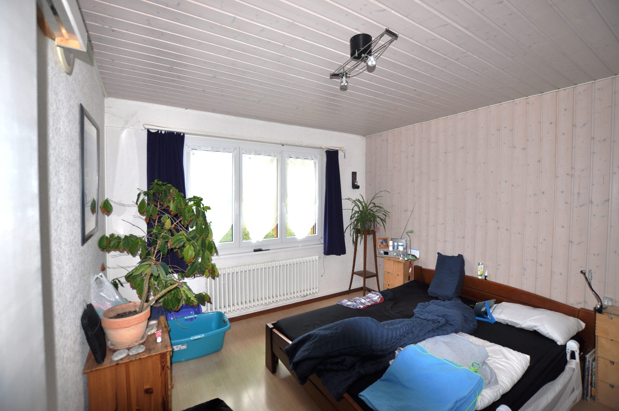 Schlafzimmer mit Dachschräge und einfacher Einrichtung