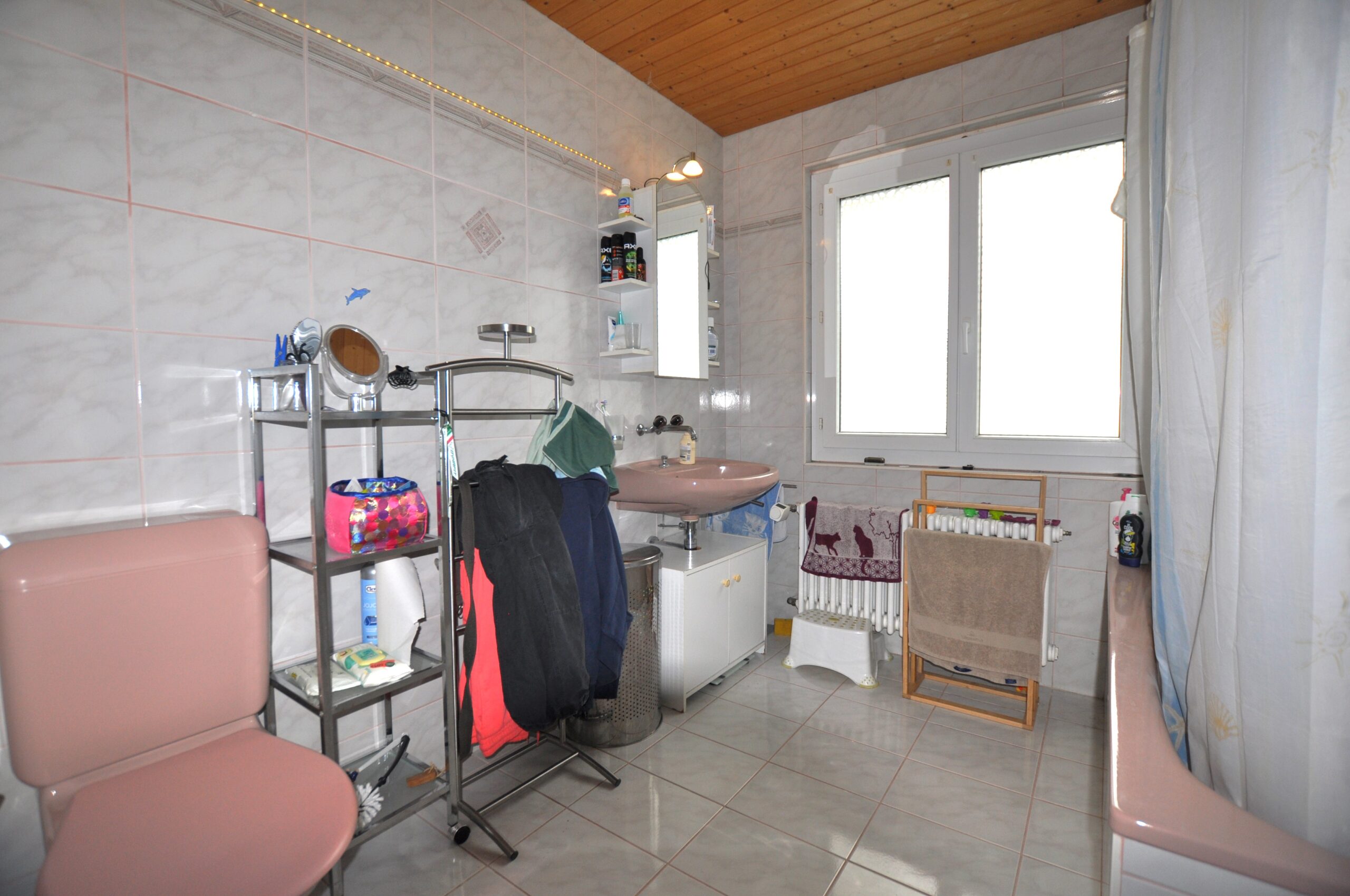 Badezimmer mit Tageslicht und rosa Sanitärkeramik