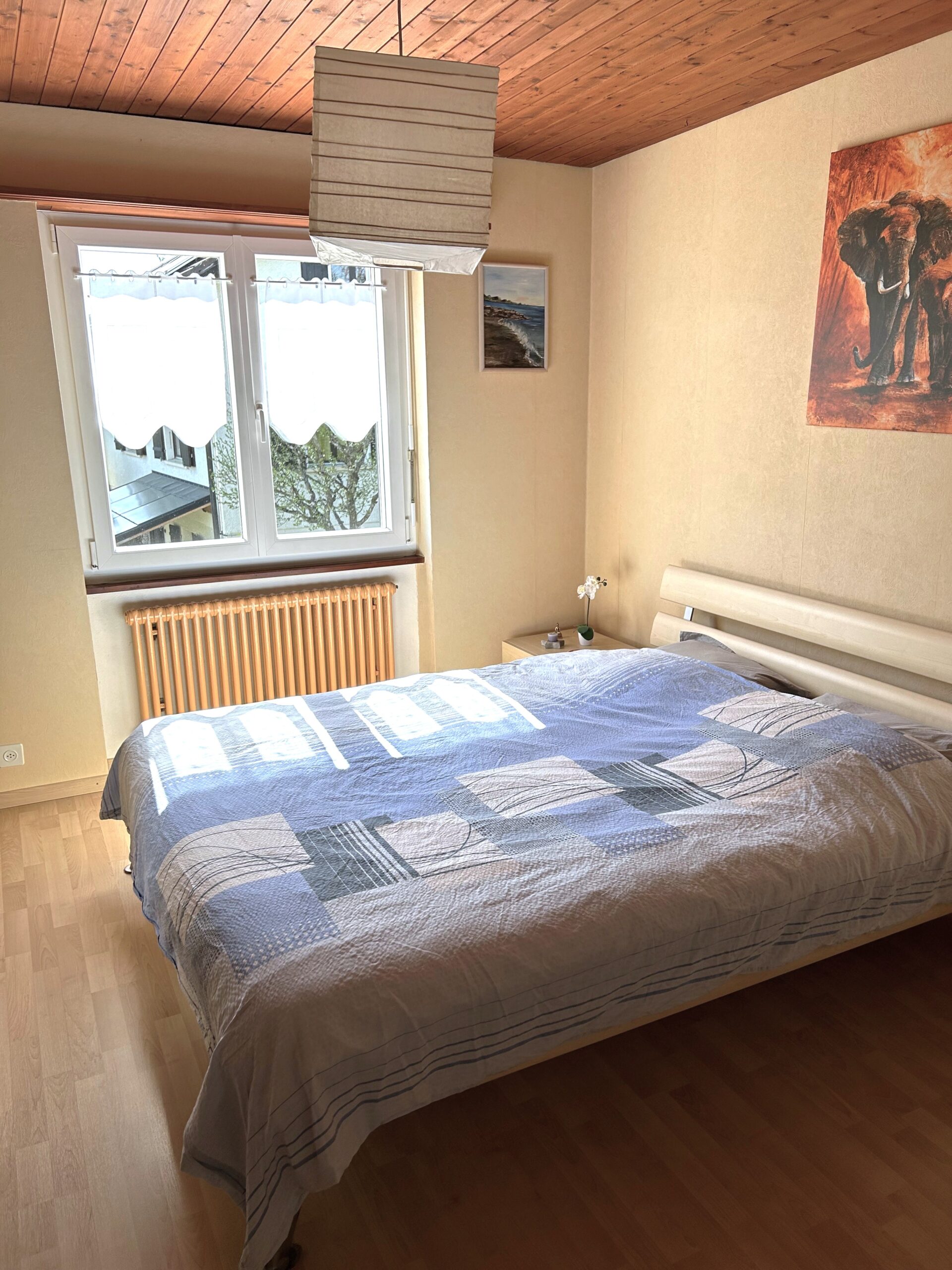 Helles Schlafzimmer mit Doppelbett und Fenster