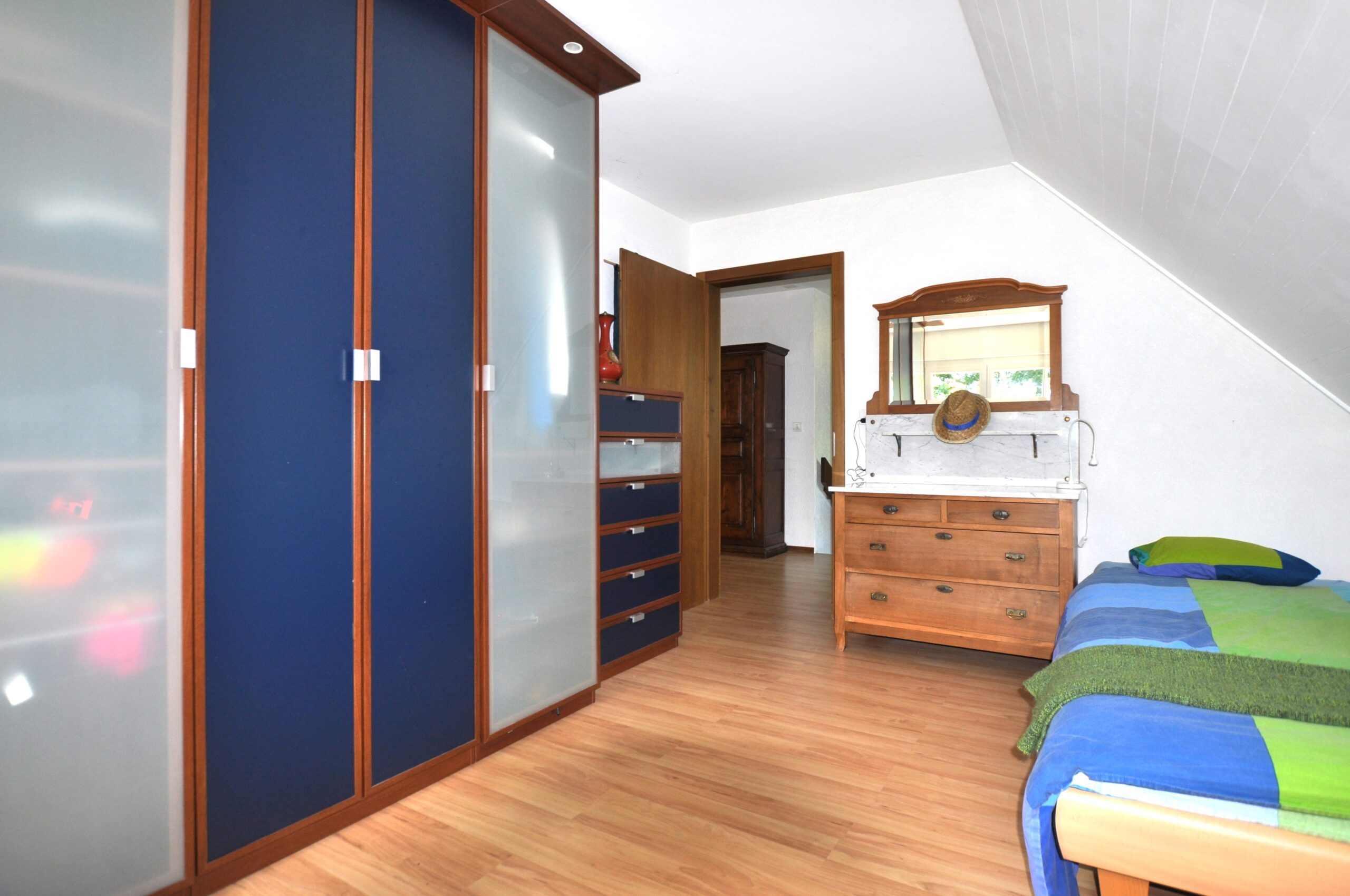 Schlafzimmer mit Schrankwand und Einzelbett