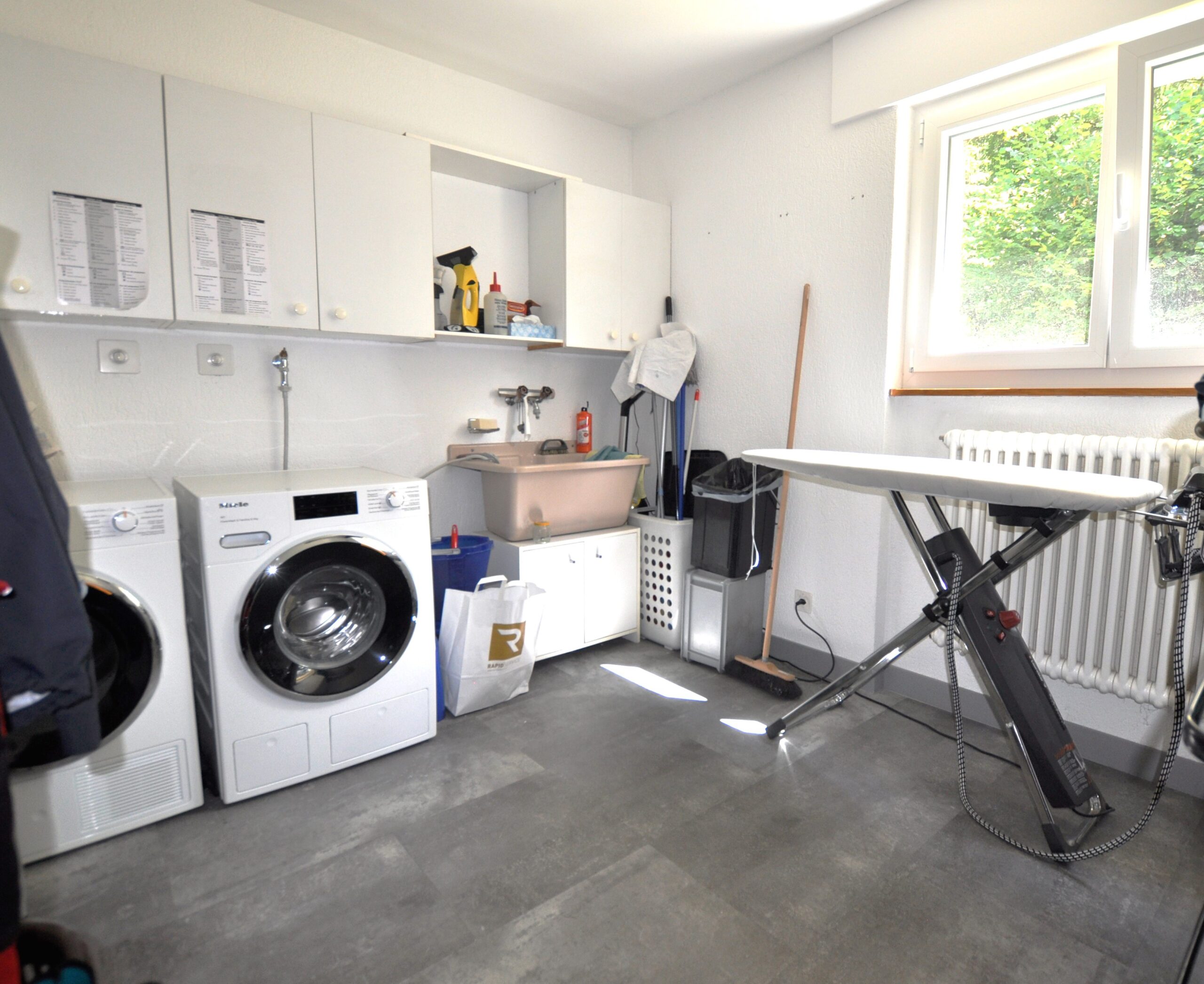 Hauswirtschaftsraum mit Waschmaschine und Pflegeausstattung