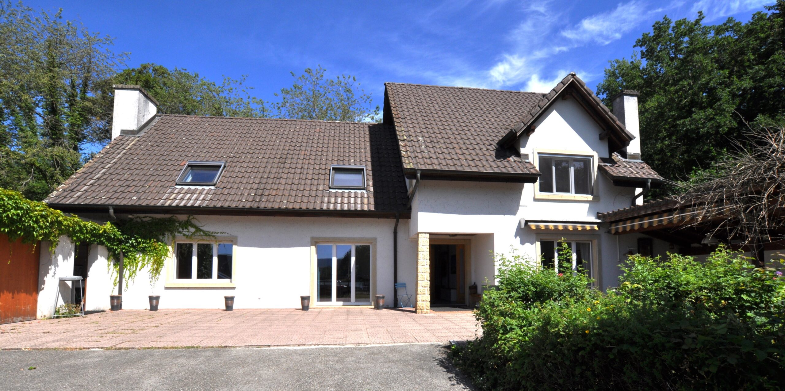 Ein freistehendes Wohnhaus mit Walmdach und Vorgarten
